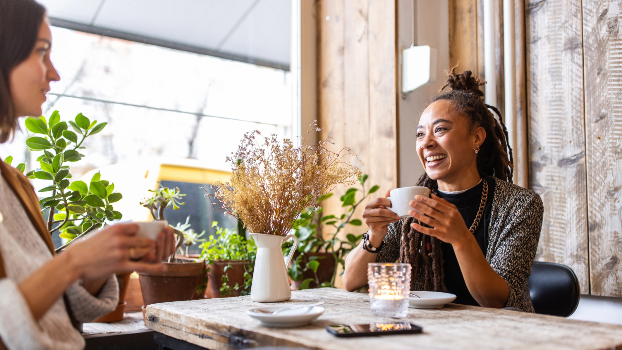 Two businesswomen talking while having a coffee at restaurant.