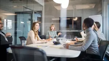 Young businesswoman leading a meeting in office. Multiracial group of professionals having meeting in conference room