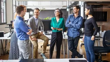 Businessmen and businesswoman having a standing meeting in modern office.