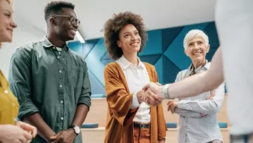 A new employee shakes hands with their team members