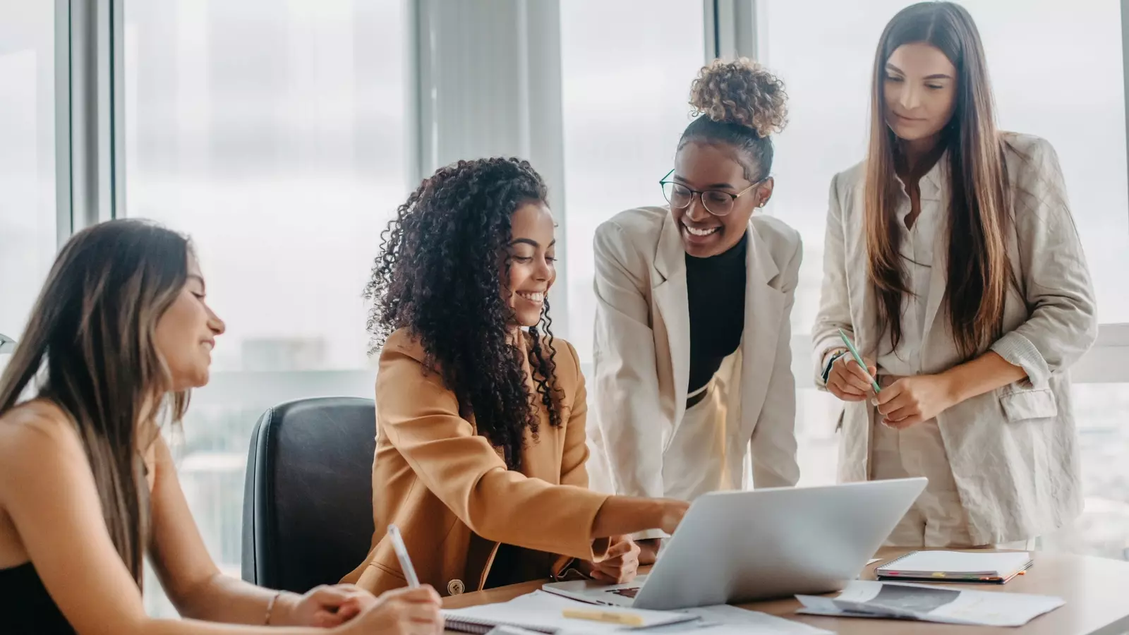 Four woman working together at a desk