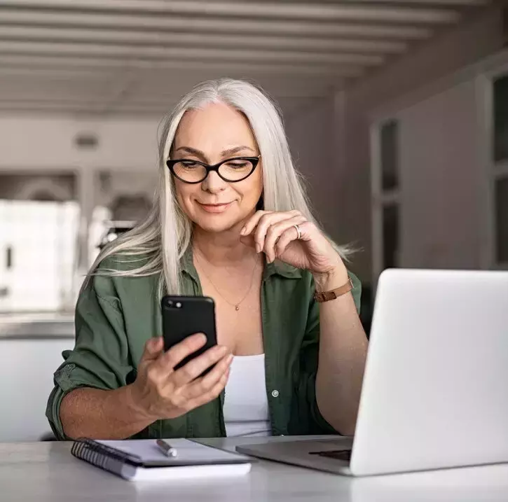 Worker checking her phone at her desk