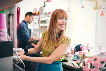 Small business employees at flower shop smiling behind counter at a great place to work